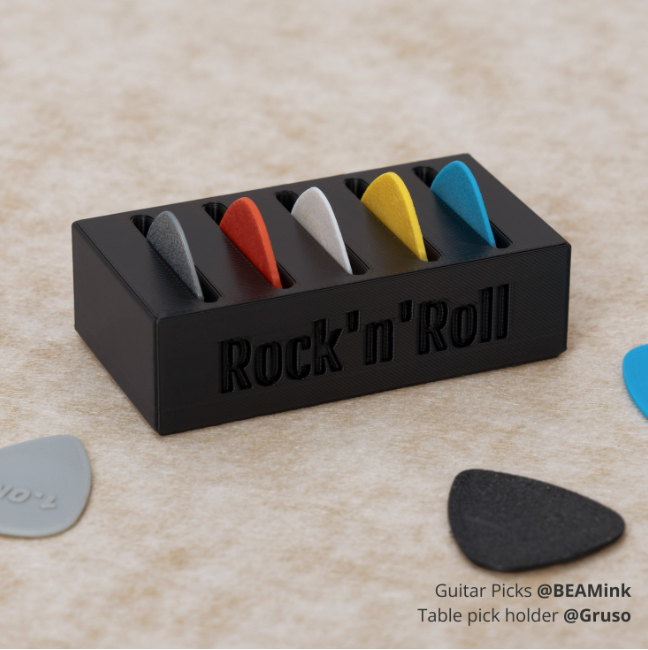 PLA TOUGH+ Black table pick holder with colorful guitar picks on a beige surface